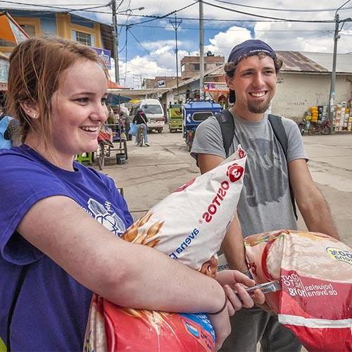 Two students carrying flour during a service trip in Peru.